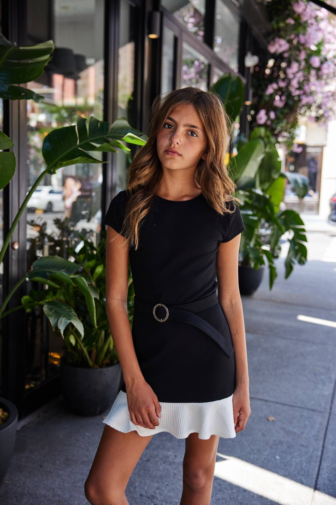 Woman wearing a black dress with a white hem in an urban setting