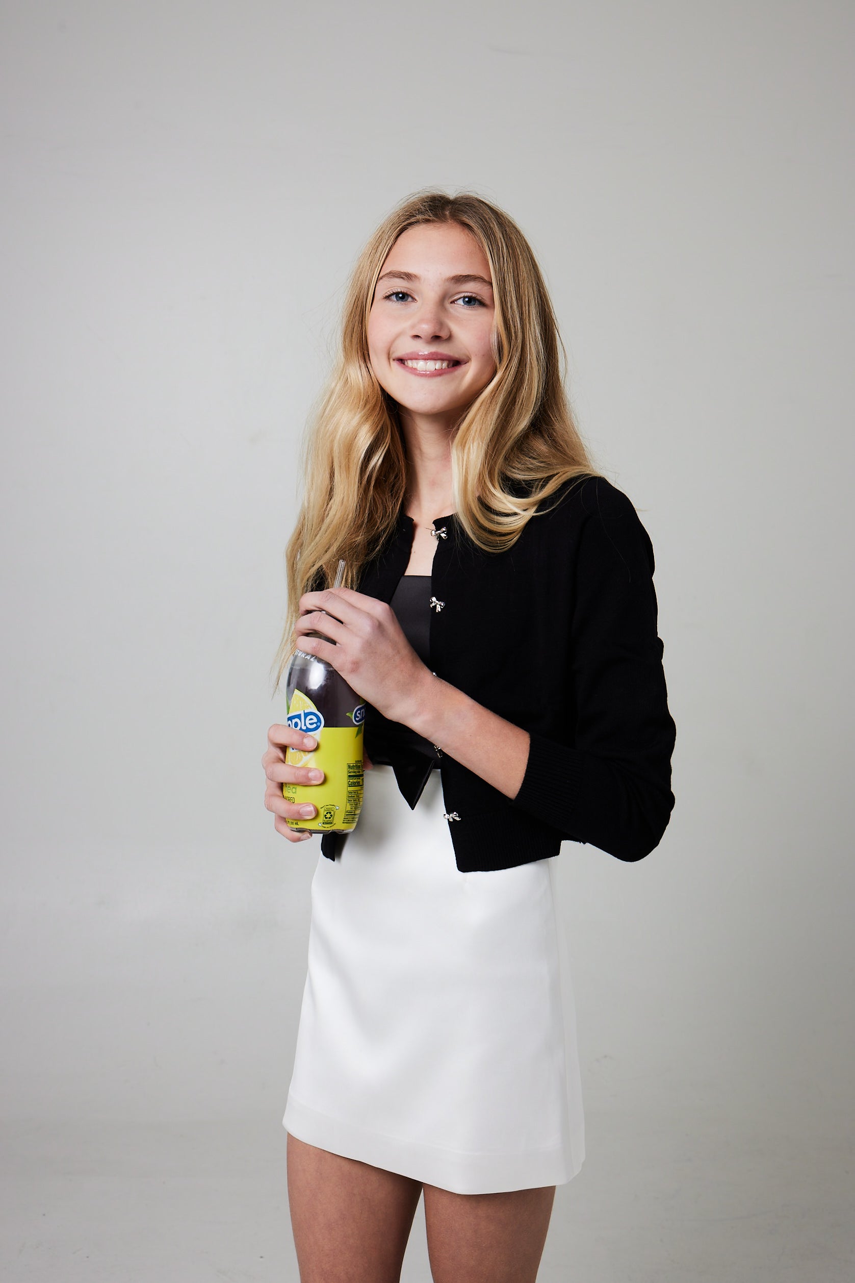 Woman holding a bottle with a gray background